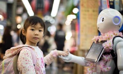 Child holding the hand of a robot.