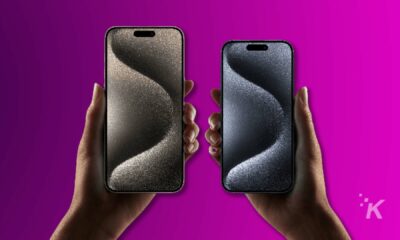 Iphone 15 in hands purple background