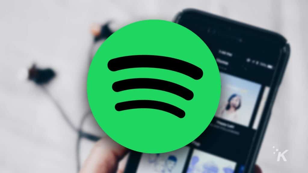 how to download songs from spotify and listen to them offline Spotify logo on blurred background