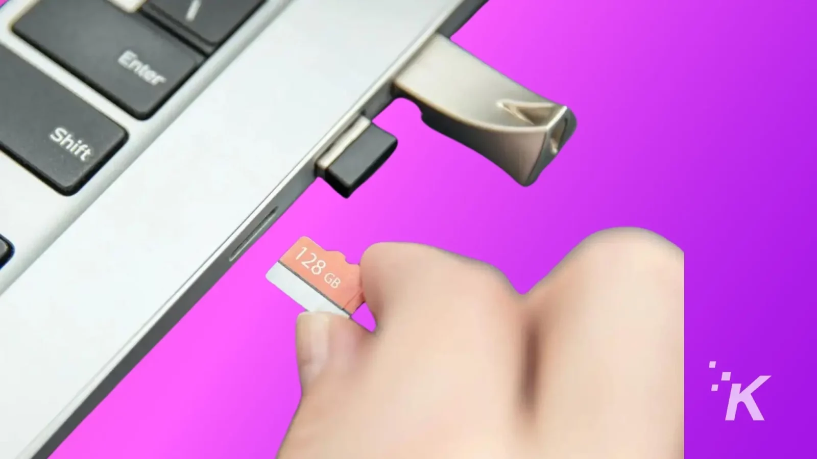 how to transfer a wyze camera to a new owner A hand is inserting a 128 gb sd card into a laptop's card reader slot against a vibrant purple background with visible laptop keyboard keys.